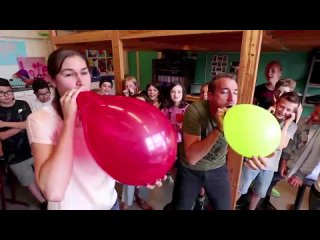 teacher participates in a blow to pop race and pops her red balloon yay